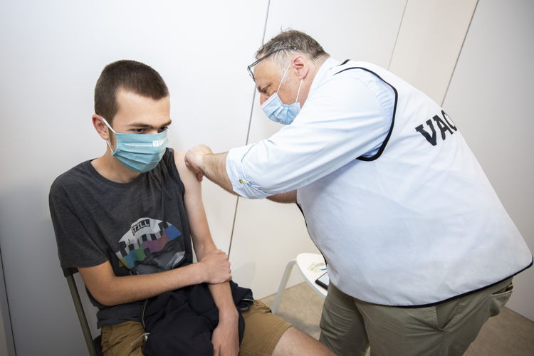 Op de prikdag voor jongeren in VacCovid vaccineert BV (bekende vaccinator) prof. Marc Van Ranst  een bezoeker. 
