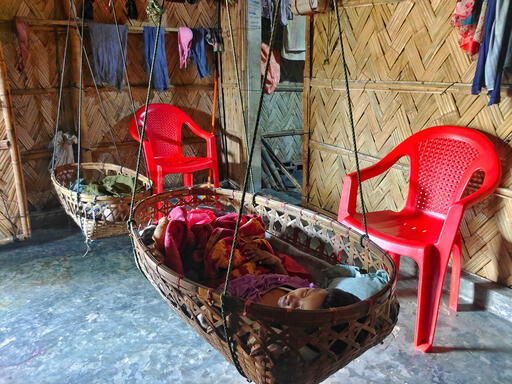 A child sleeps in a cradle suspended from the roof of a shelter in one of the camps. Cox’s Bazar, Bangladesh, October 2023 © Ro Yassin Abdumonab