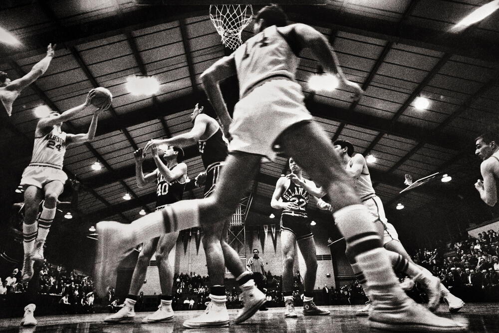 AKG7728872 1960s 1970s COLLEGIATE BASKETBALL GAME PLAYERS UNDER THE HOOP SHOOTING TO SCORE © akg-images / ClassicStock