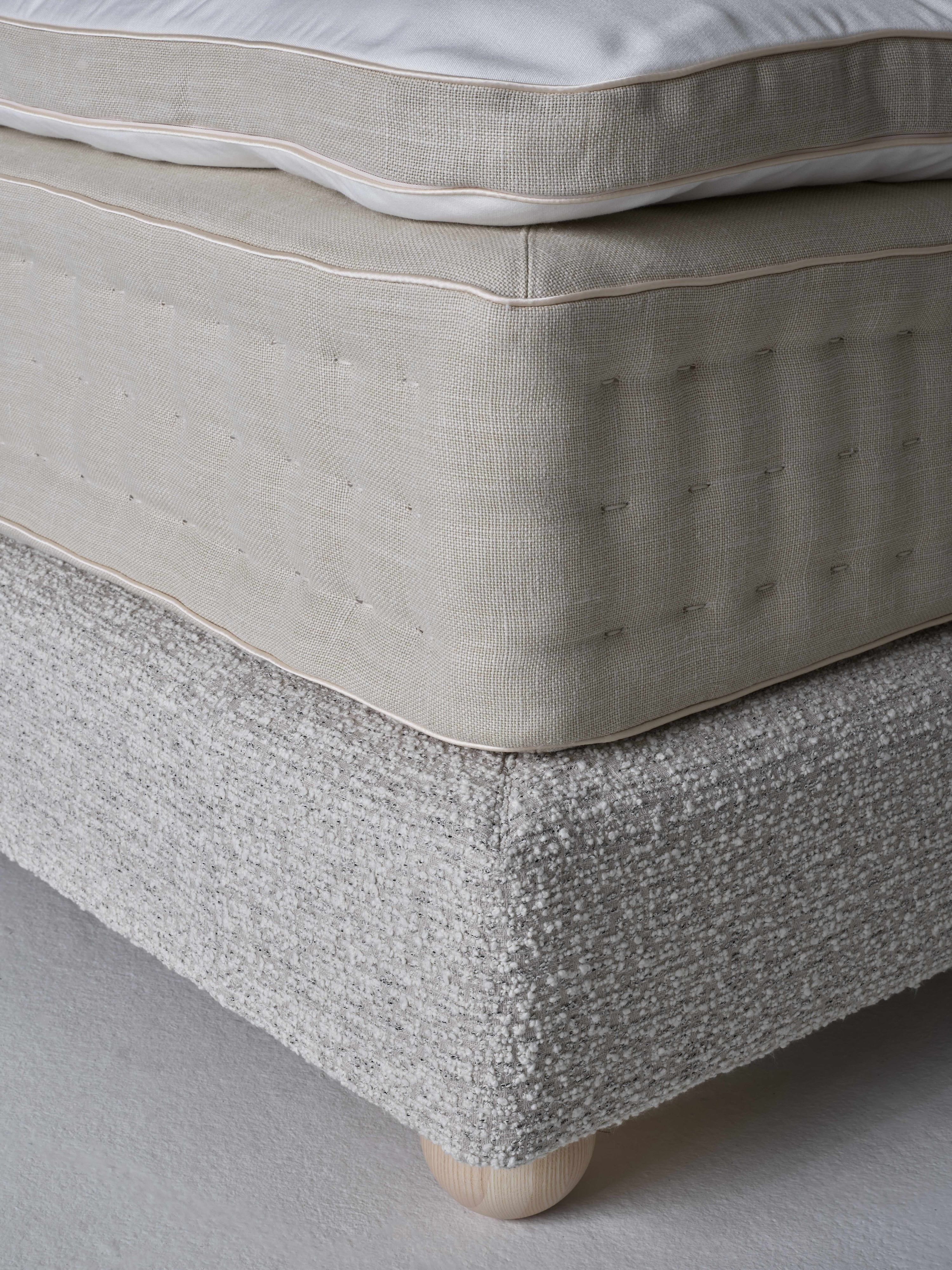 Linen and bouclé on mattress and sommier with seamless corners.