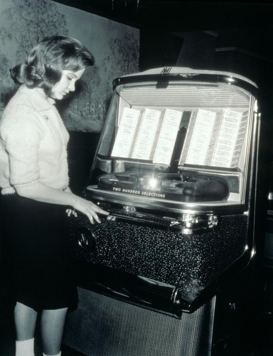 AKG2149712 Young woman selecting music on coin-operated jukebox. © ClassicStock / akg-images / Ewing Galloway AKG2149712 Young woman selecting music on coin-operated jukebox. © ClassicStock / akg-images / Ewing Galloway