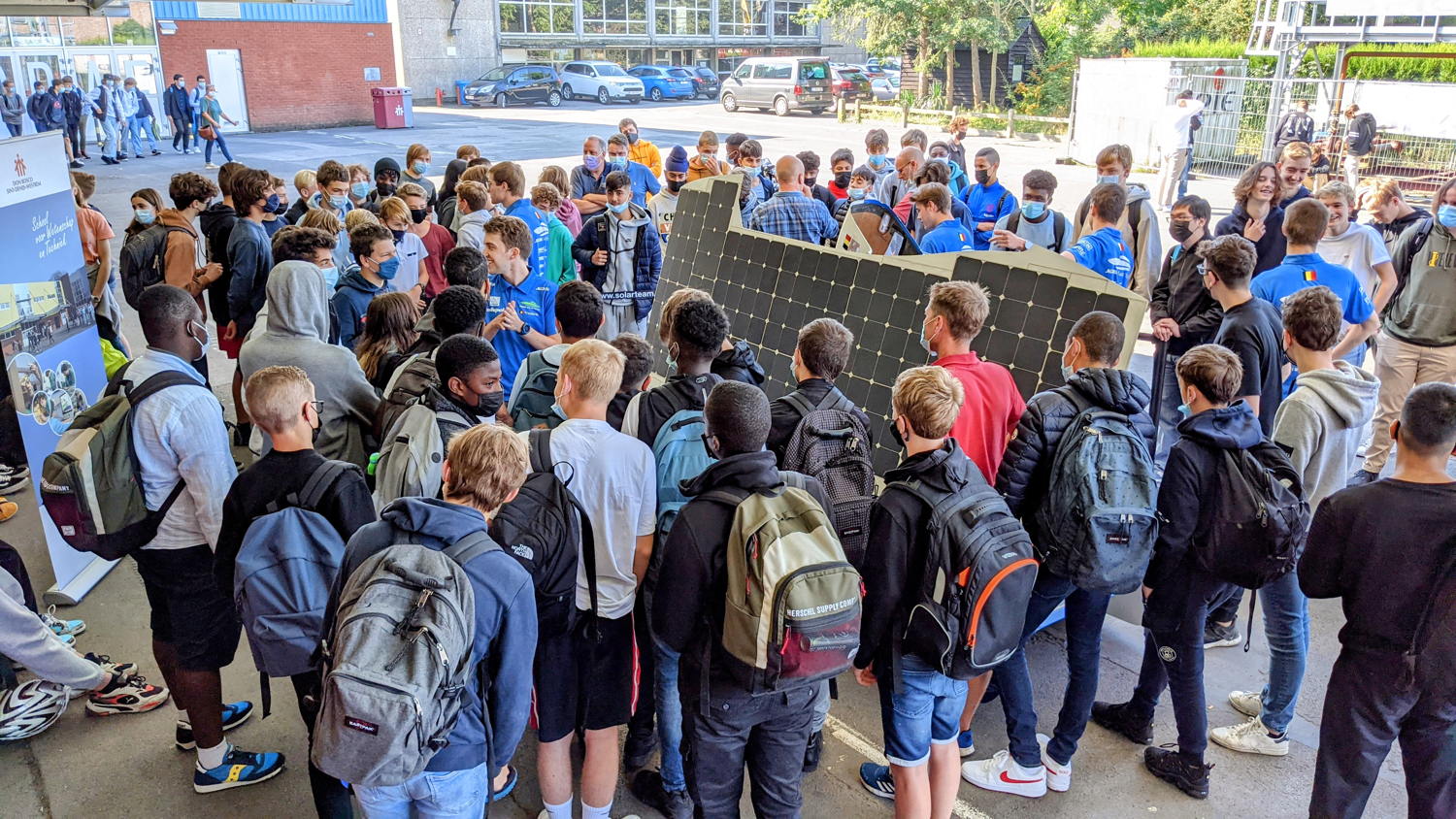 Scholieren verzamelen zich rond de zonnewagen van het Agoria Solar Team