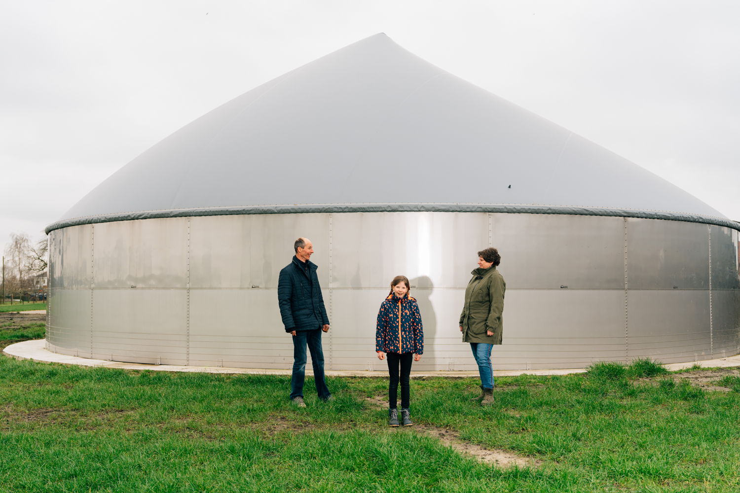 Petra, Wim et leur fille Stiene de Laerhoeve devant leur fermentateur de poche qui produit de l’énergie. © Illias Teirlinck
