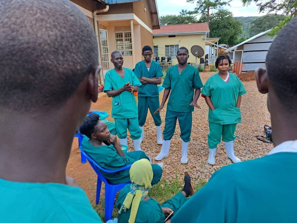 Hygienists meet outside the Ebola Treatment Center in Mubende, Uganda. Photographer: Sam Taylor | Location: Mubende, Uganda | Date: 02/11/2022