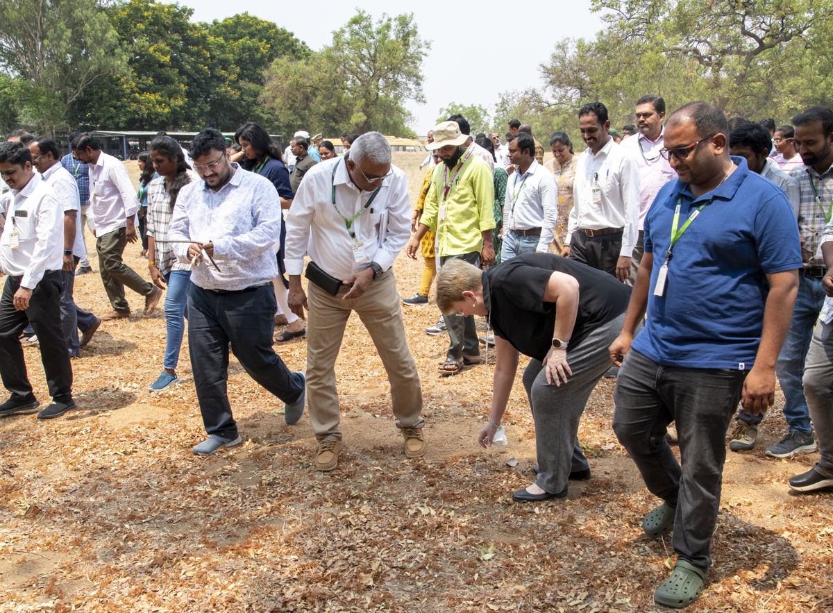 Director General of ICRISAT, Dr Jacqueline Hughes, leads by example, picking up plastic found on the walk.