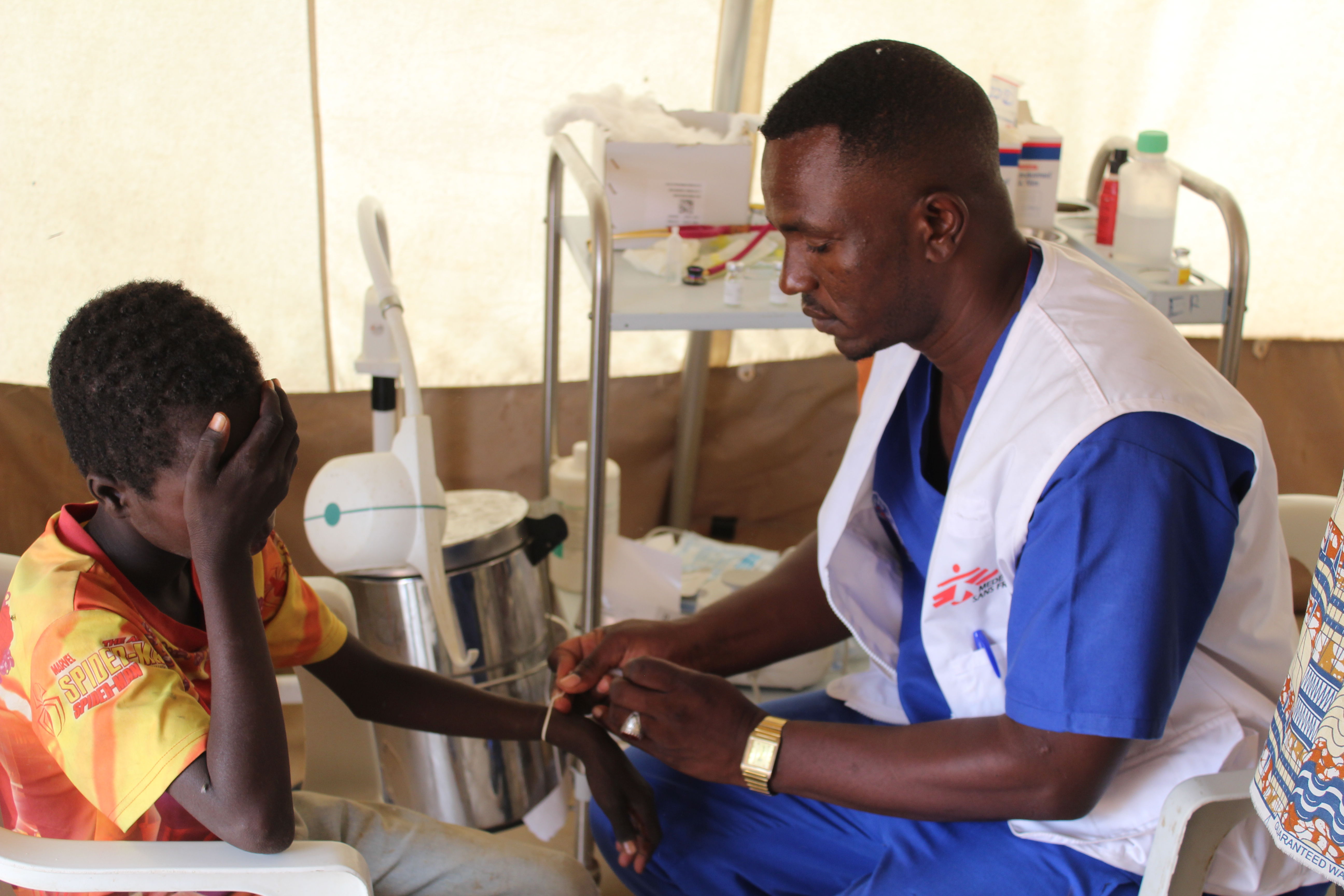 A nurse attends to a patient in the ER department at the MSF clinic in Zamzam Camp, North Darfur, providing critical care for those in need. Zamzam camp near El-Fasher | 30/08/2024 | Photographer: Mohammed Jamal.