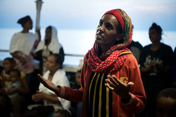 Een Eritrese vrouw bidt nadat ze gered is door een boot van AZG op 2 september 2015 ©  Gabriele François Casini/MSF