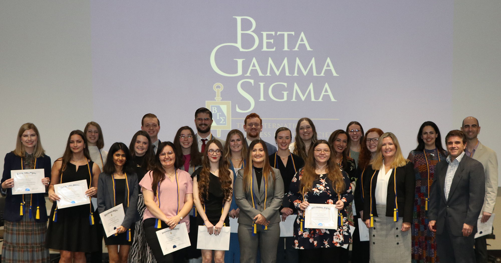 Group of individuals at UCO posing for a photo as they are inducted into an honor society.