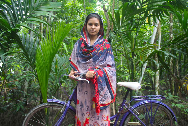 Sweeti with her bicycle that helps her travel between villages in Bangladesh ©Plan International