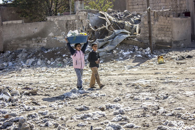 Two children help their parents clean their house of rubble. Al Mishlab, east of Raqqa city, 7 November 2017. Credit MSF/Diala Ghassan