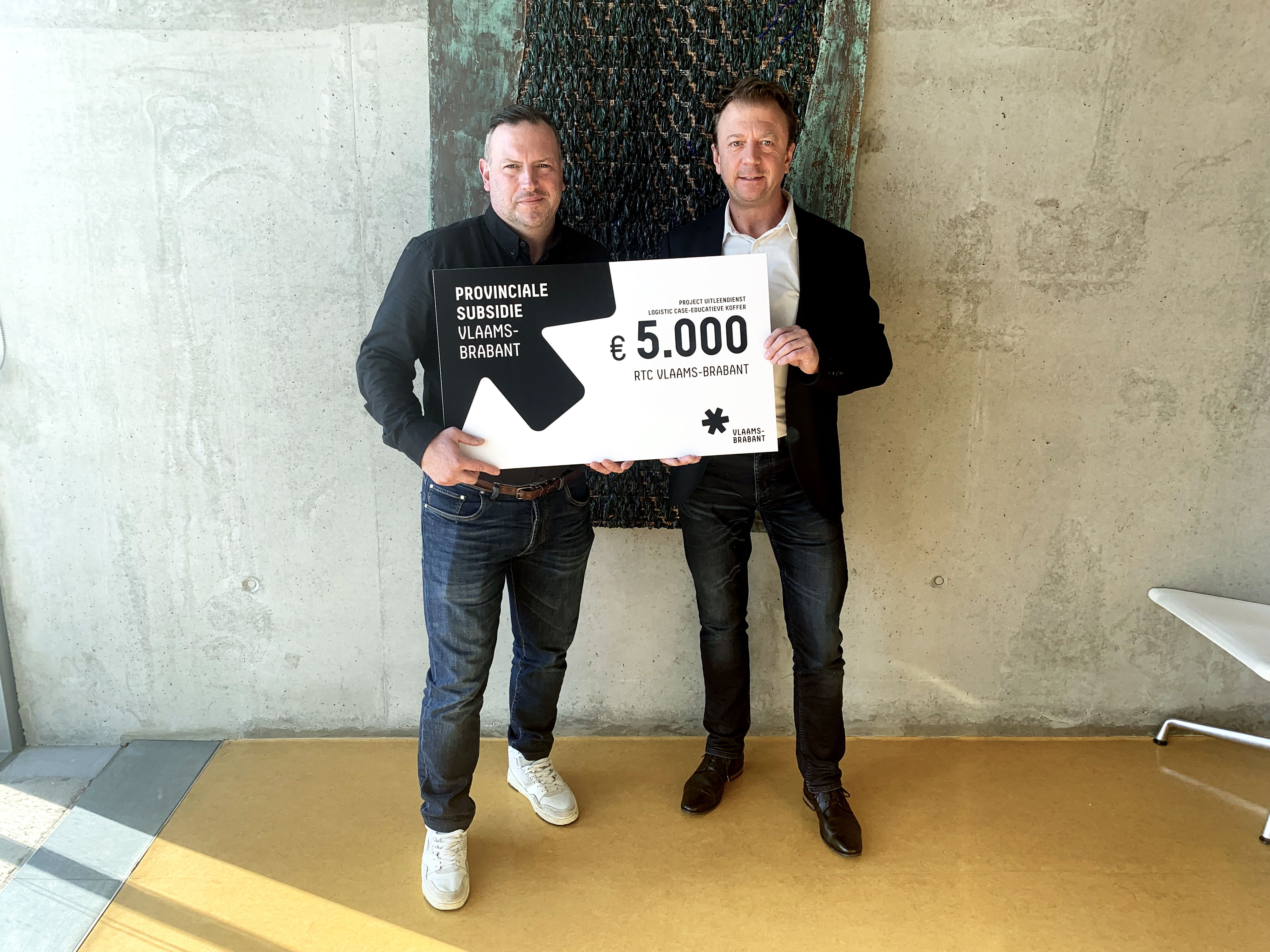Gedeputeerde Gunther Coppens overhandigt de symbolische cheque aan Raf De Boeck, directeur van RTC Vlaams-Brabant.