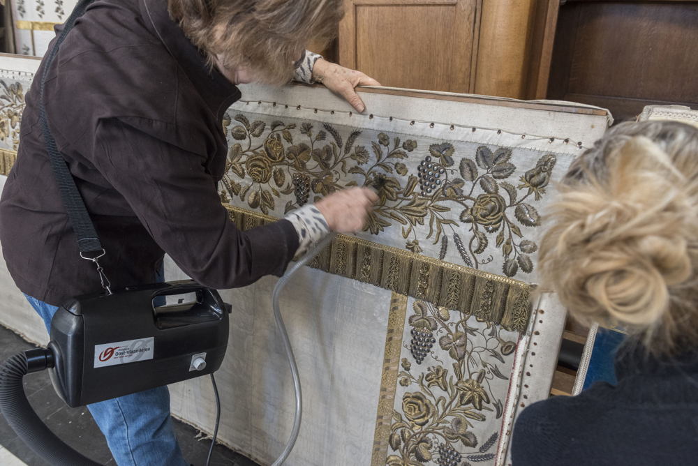 Stofzuigen met museumstofzuiger uit de uitleendienst voor erfgoedorganisaties van Provincie Oost-Vlaanderen