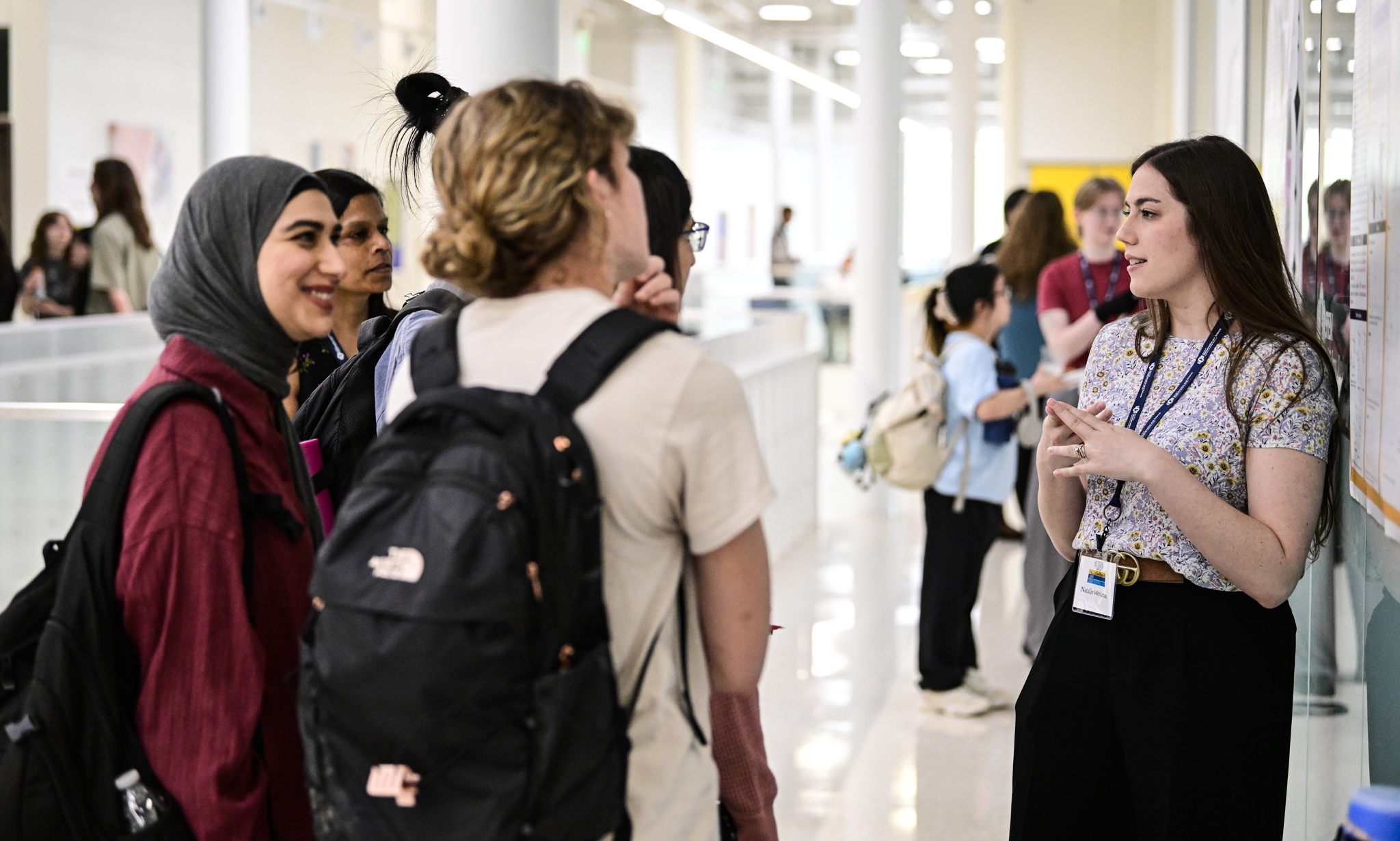 A person presenting their poster at the 2025 Tri-Center Symposium.