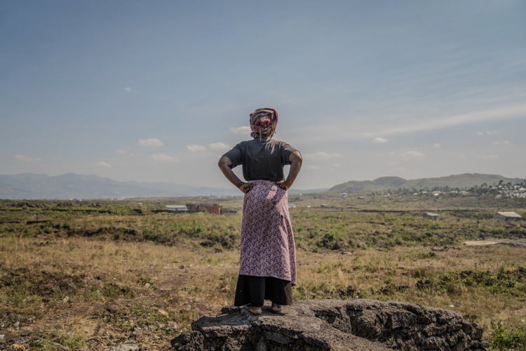 Esther looks at the horizon standing on a stone on the outskirts of Elohim camp. Copyright: Moses Sawasawa