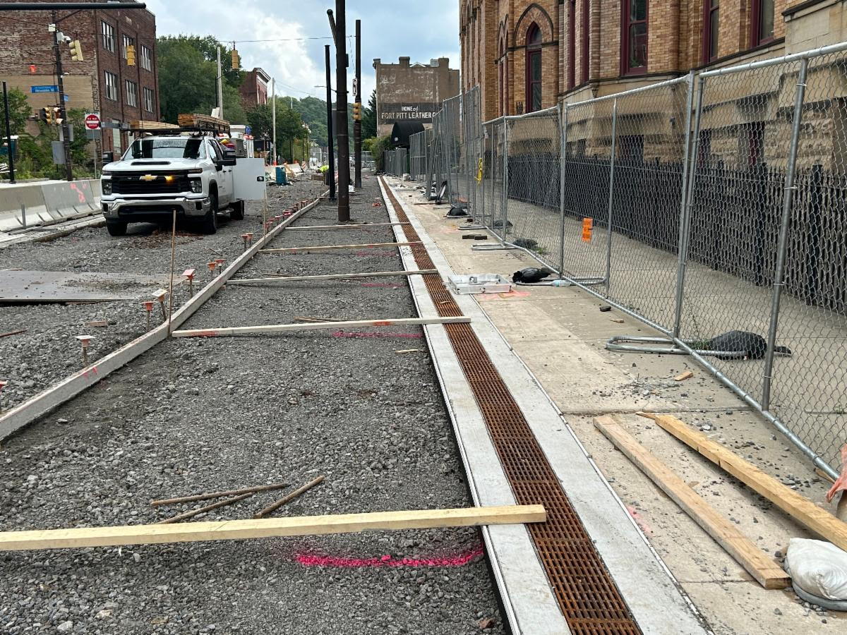 Sidewalk restoration along Fifth Avenue near the former Fifth Avenue School. Sidewalk trench drains are visible on the right.