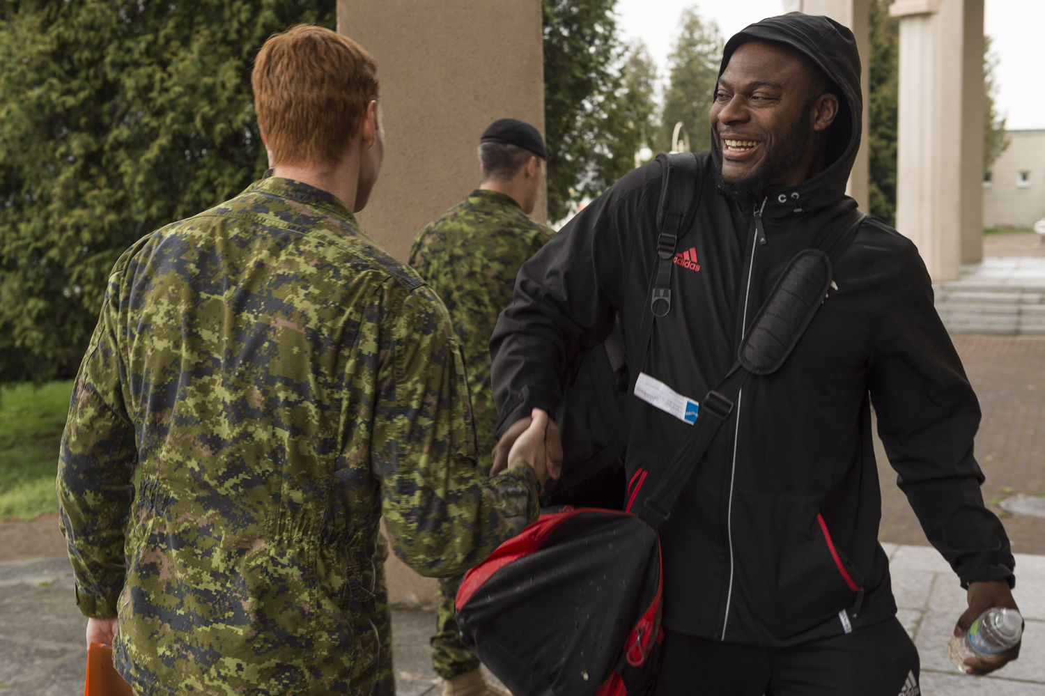 Charleston Hughes des Stampeders de Calgary rencontre des militaires déployés dans le cadre de l'opération UNIFIER à Starychi, en Ukraine. CplC Mathieu Gaudreault, Caméra de combat des Forces canadiennes