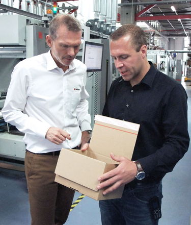 Sebastian Würth (right) and Michael Linden from Bobst Meerbusch are pleased with the accuracy and productivity of the EXPERTFOLD 165 e-commerce version folder-gluer in the production of packaging with self-adhesive seals.