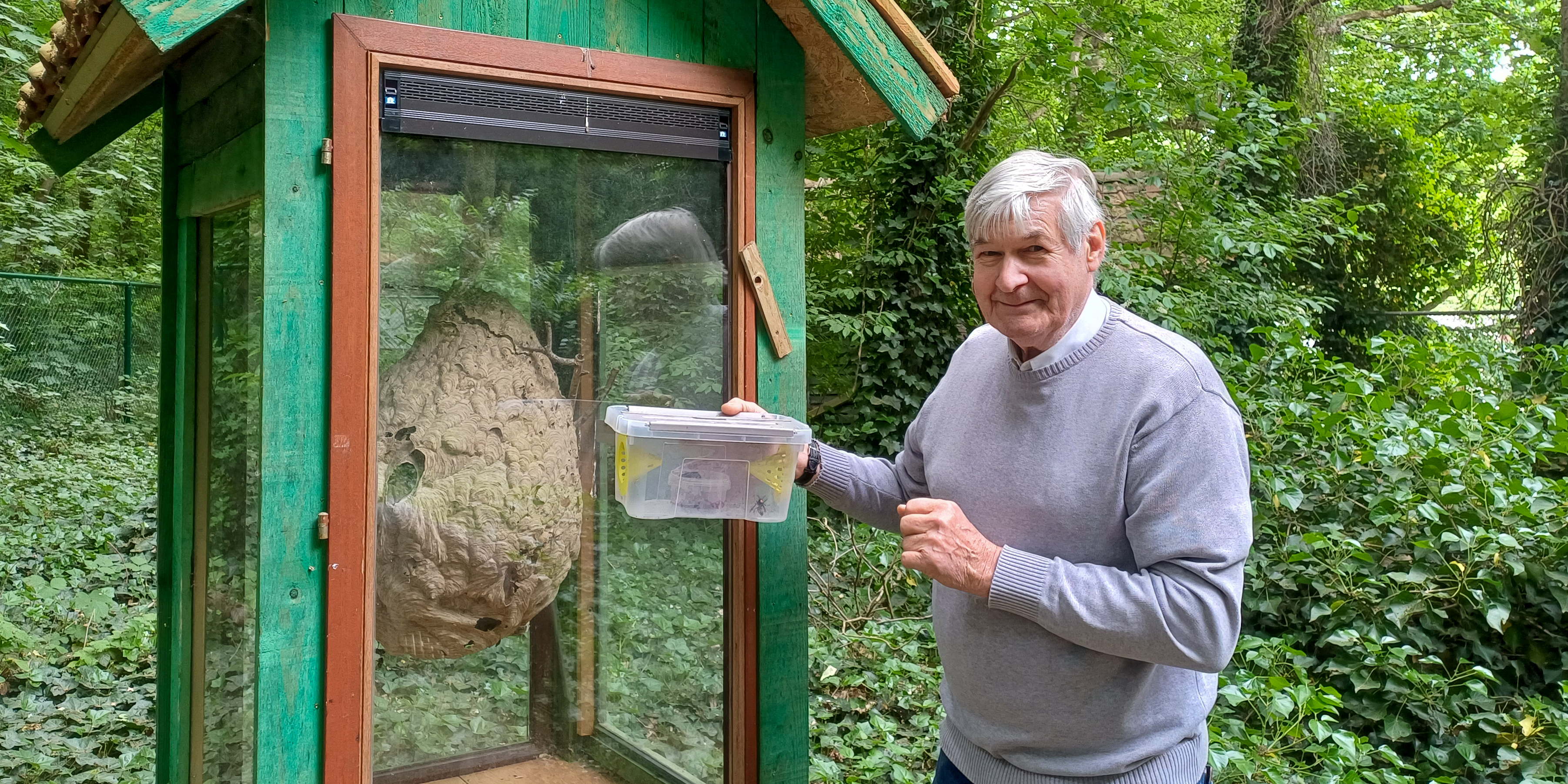 Imker Marcel Cuylaerts poseert met een gevulde val.