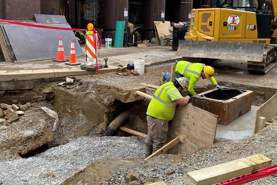 Contractors are pouring a catch basin outside of Wood Street Station