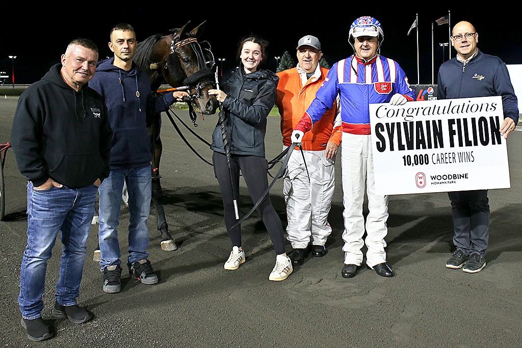 Sylvain Filion receives a sign of congratulations from Bill McLinchey, Vice-President of Standardbred Racing, following his 10,000th career win. (New Image Media)