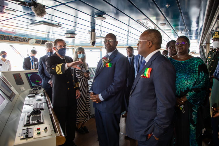 •	Kapten Taylor Perez på Global Mercy, till vänster, ger Senegals president Macky Sall och Guinea-Bissaus president Umaro Mokhtar Sissoco Embalo, tillsammans med en delegation av representanter, en rundtur på bryggan.