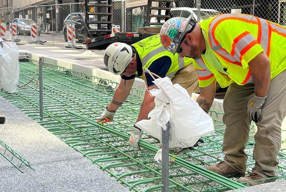 The PRT contractor is placing steel rebar before pouring a concrete pad that will support the new bus shelter at William Penn Place Station