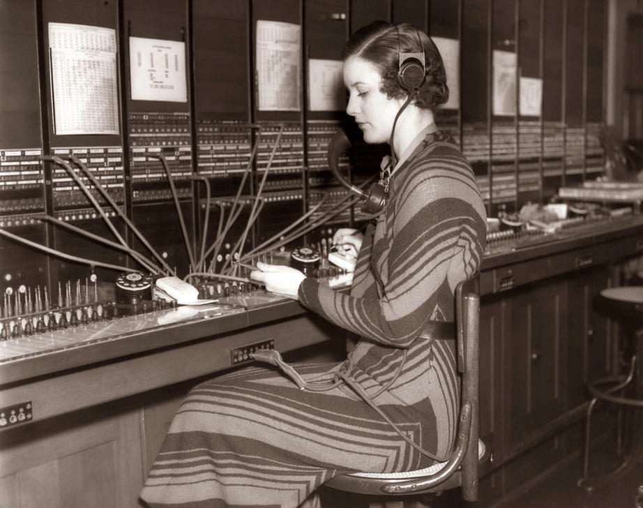 AKG2151441 1930s TELEPHONE OPERATOR SITTING AT LARGE MANUAL SWITCHBOARD DIRECTING CALLS. © ClassicStock / akg-images / H. Armstrong Roberts