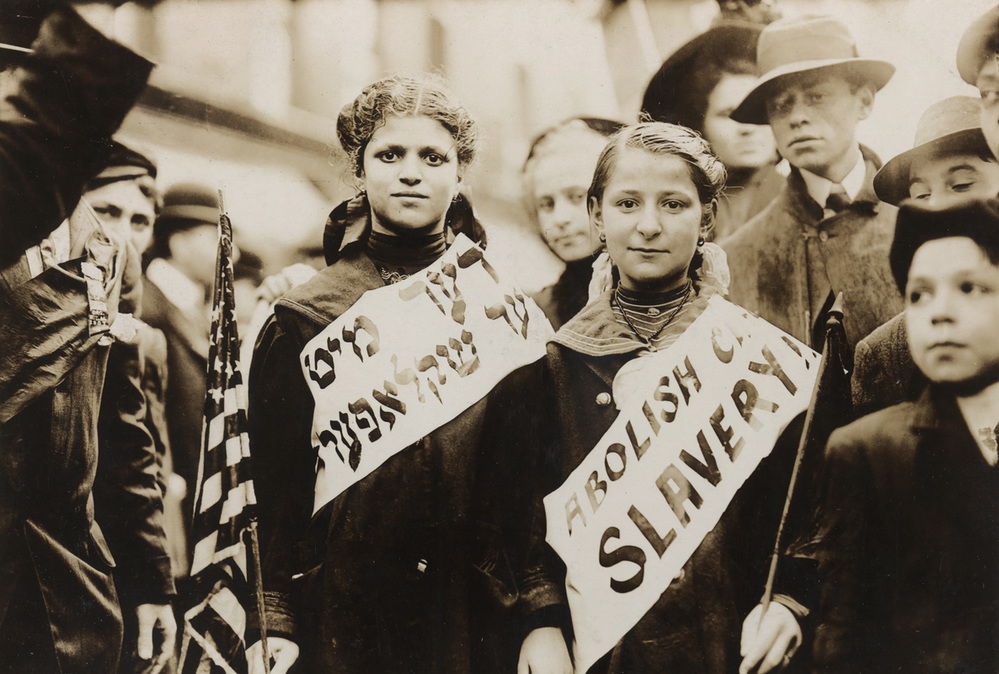 Two girls wearing "Abolish Child Slavery" banners in English and Yiddish. They were photographed at a labor parade held in New York City on May 1, 1909. AKG8729358 © akg-images / Science Source