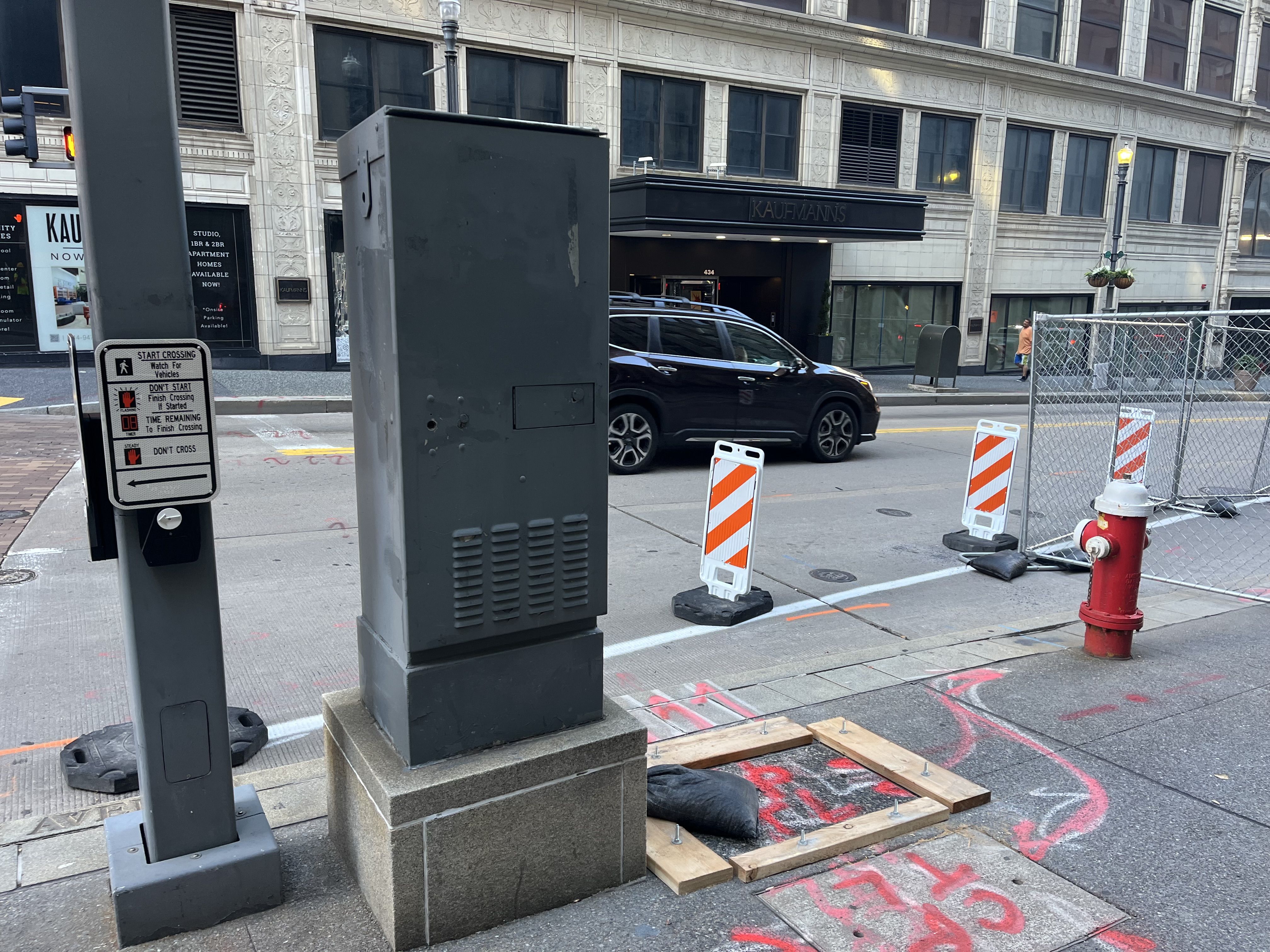 A traffic signal box with pavement markings placed in preparation for upcoming work