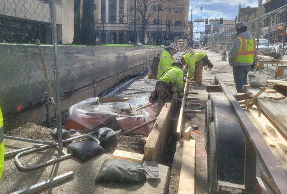 Contractors placing new curb at Forbes Avenue and South Bouquet Street
