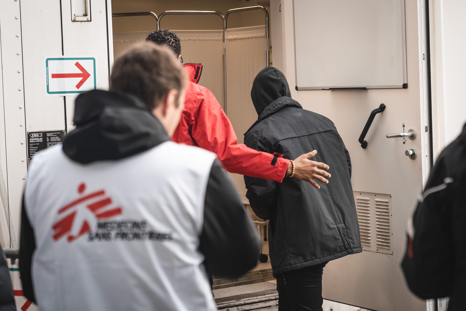 een asielaanvrager wordt binnengeleid in de medische container van Artsen Zonder Grenzen aan Pacheco registratriecentrum (c) AZG/Pierre Fromentin