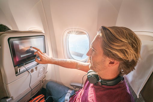 A passenger exploring the latest Ventertainment system and noise canceling headphones