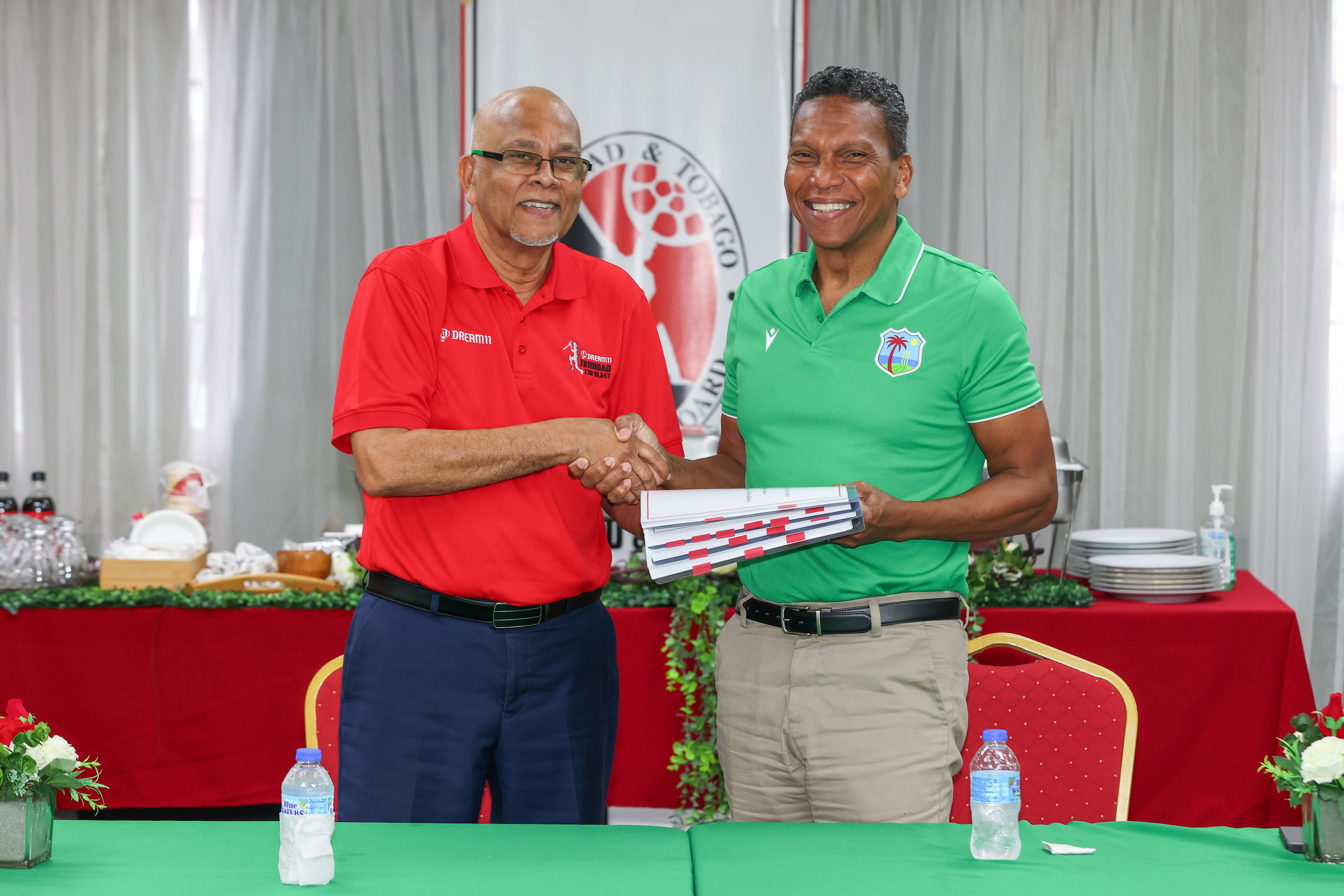 TTCB President Azim Bassarath (left) making a presentation to CEO Chris Dehring (right) of the cricket board's official articles of incorporation, strategic plan and development strategy.