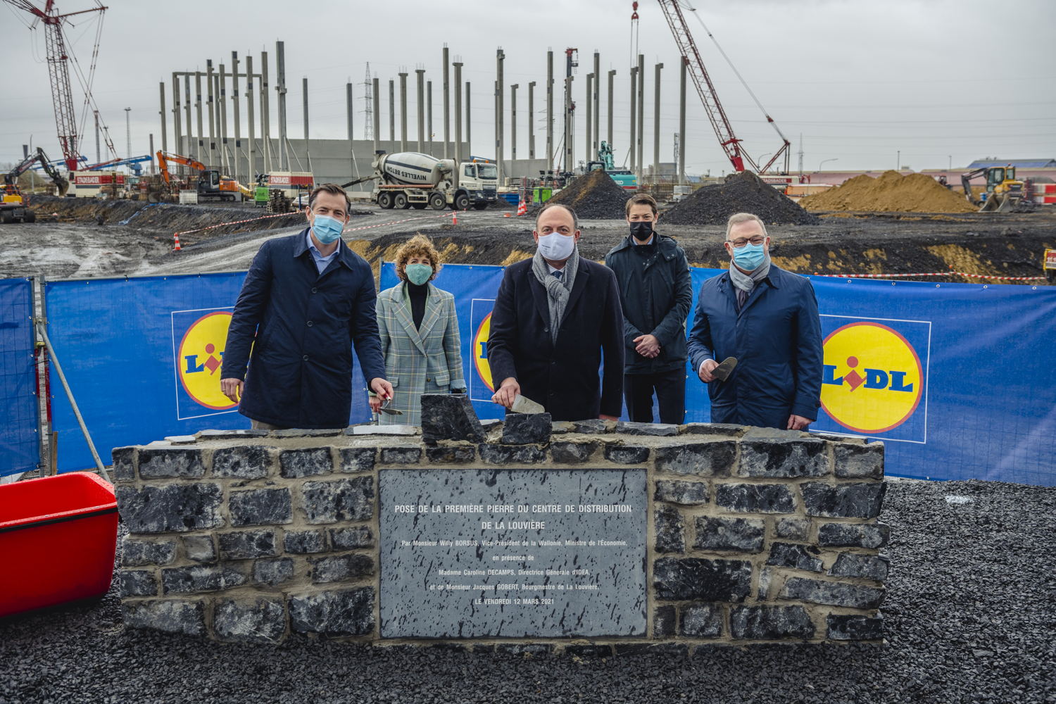 Op de voor grond. V.l.n.r: Boudewijn van den Brand, CEO Lidl, Minister van Economie, Willy Borsus, Jacques Gobert, Burgmeester van La Louvière en Voorzitter van IDEA. Achtergrond : Caroline Decamps,  algemeen Directrice van IDEA en Evan Lesage, Directeur Vastgoed Lidl.