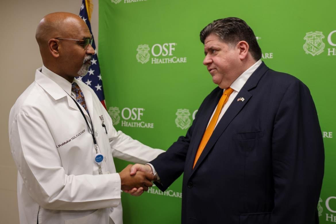 Gov. Pritzker shakes hands with a healthcare professional at OSF Healthcare.