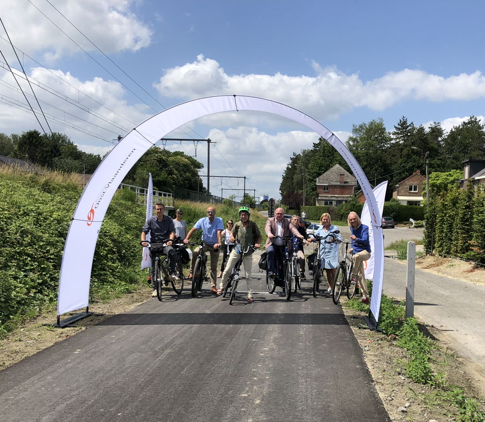 Gedeputeerde Riet Gillis en burgemeester Alain Pardaen fietsen samen met het schepencollege de nieuwe fietsverbinding in