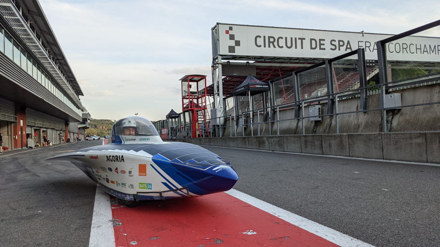De zonnewagen staat klaar in de pitlane van het circuit.