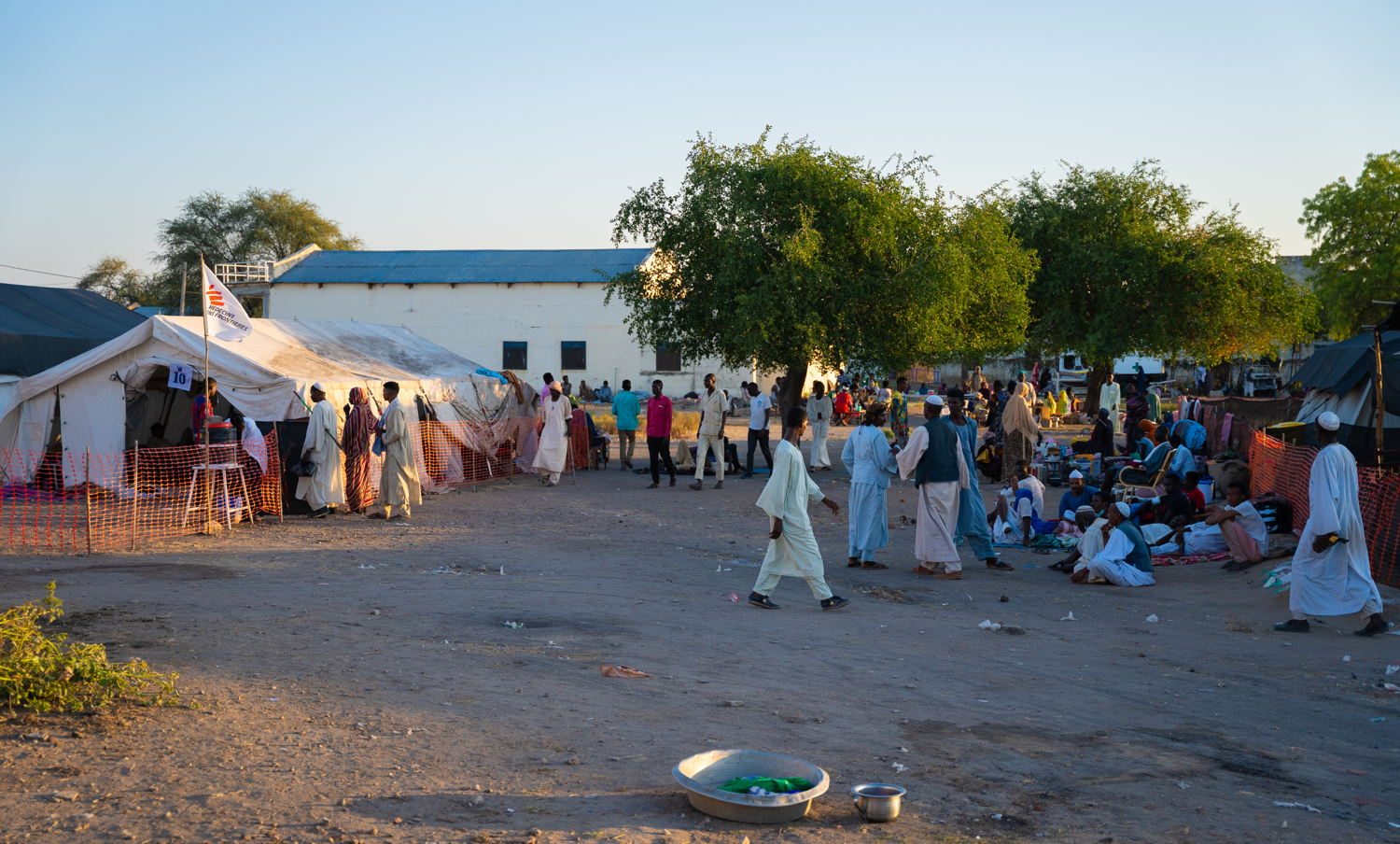 Verzorgers wachten buiten de pre- en postoperatieve zorgeenheid om hun dierbaren te bezoeken in het Renk County Hospital. Artsen Zonder Grenzen en ICRC behandelen hier oorlogsgewonden. © Isaac Buay/MSF