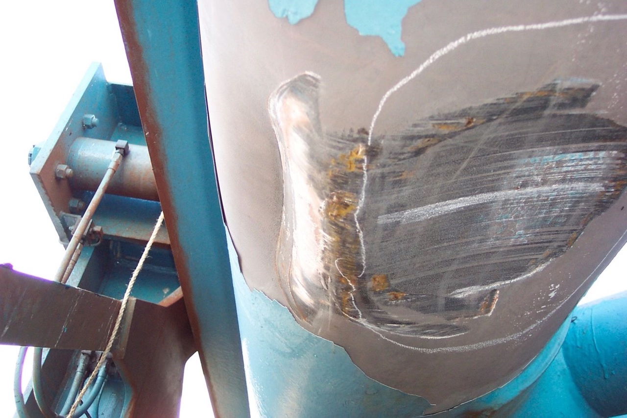 The bottom of a boom chord was damaged when it accidentally contacted the wheel house of a container vessel.