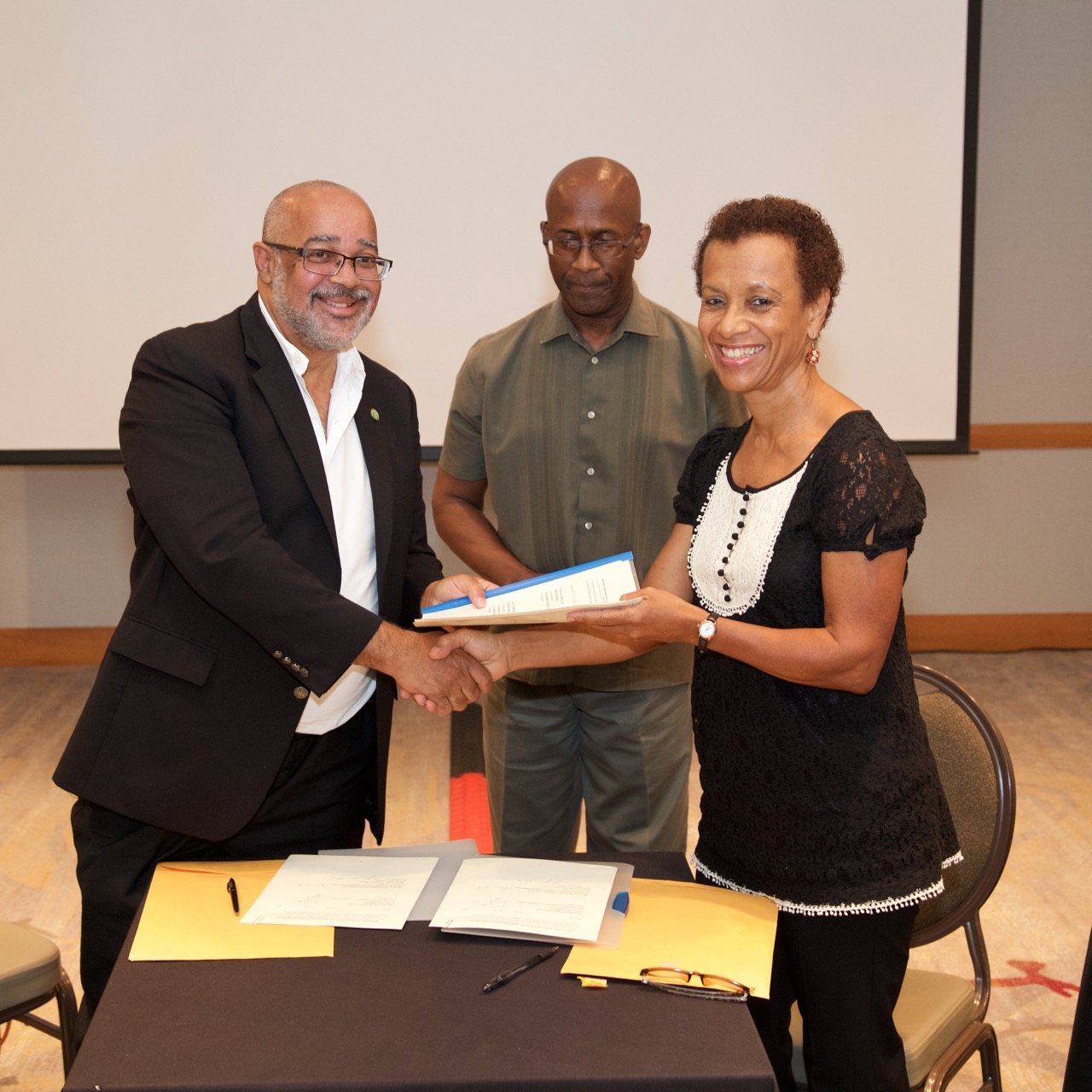 OECS Director General, Dr. Didacus Jules, and Professor Jessica Byron, Director of the UWI Institute of International Relations, complete MOU signing.