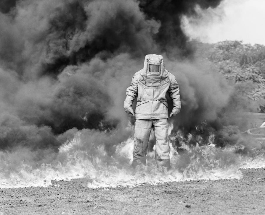 AKG2149473 1960s FIREMAN IN ASBESTOS SUIT STANDING IN SMOKE AND FLAMES.  © ClassicStock / akg-images / H. Armstrong Roberts