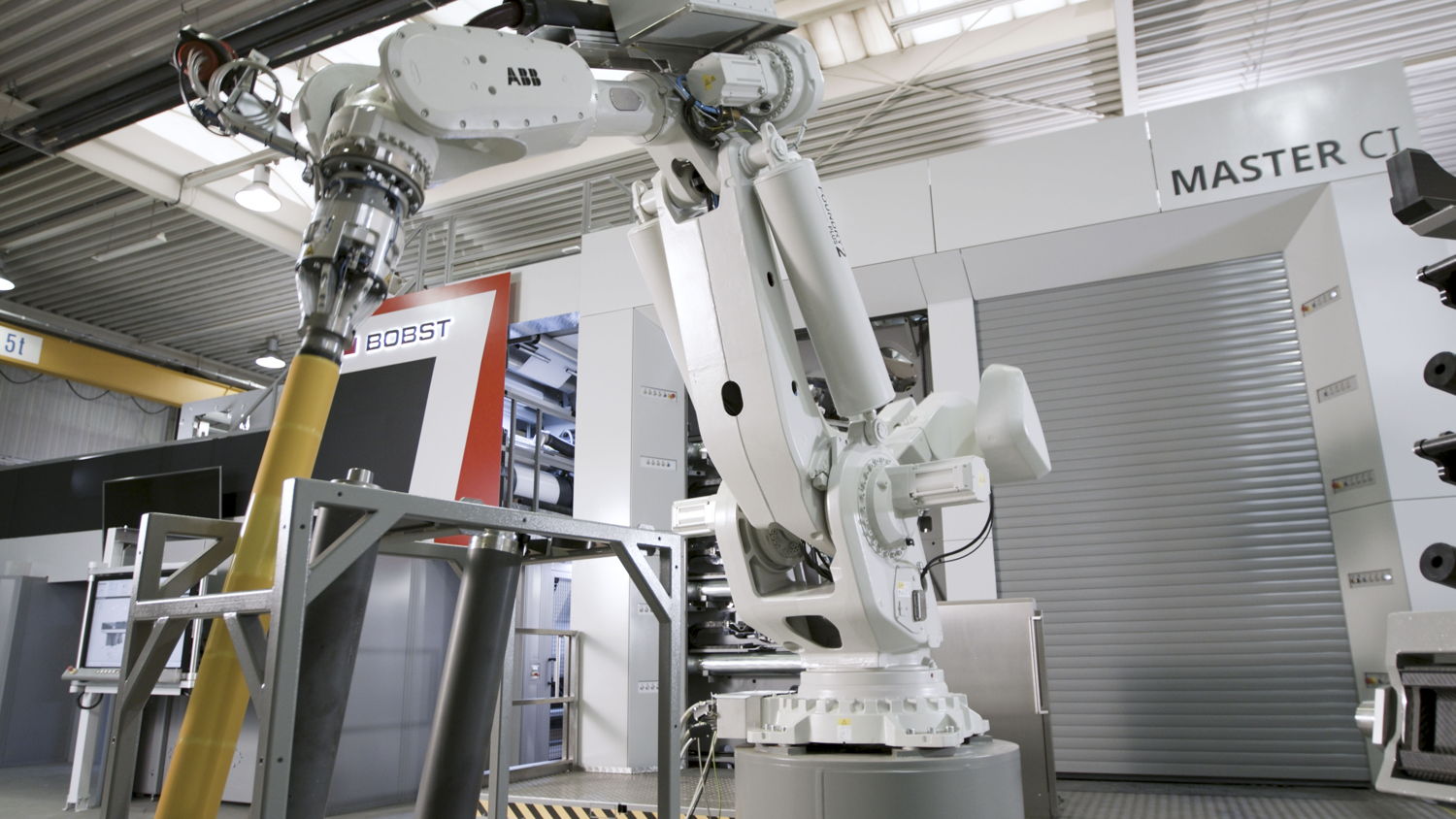 Nahansicht des Robotersystems smartDROID vor dem Druckbereich der Zentralzylinder-Flexodruckmaschine BOBST MASTER CI.