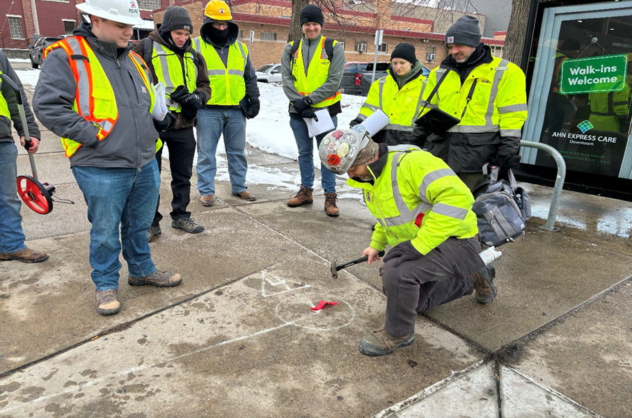 “Pole Spotting” crew placing sidewalk markings at future traffic signal locations “Pole Spotting” crew placing sidewalk markings at future traffic signal locations
