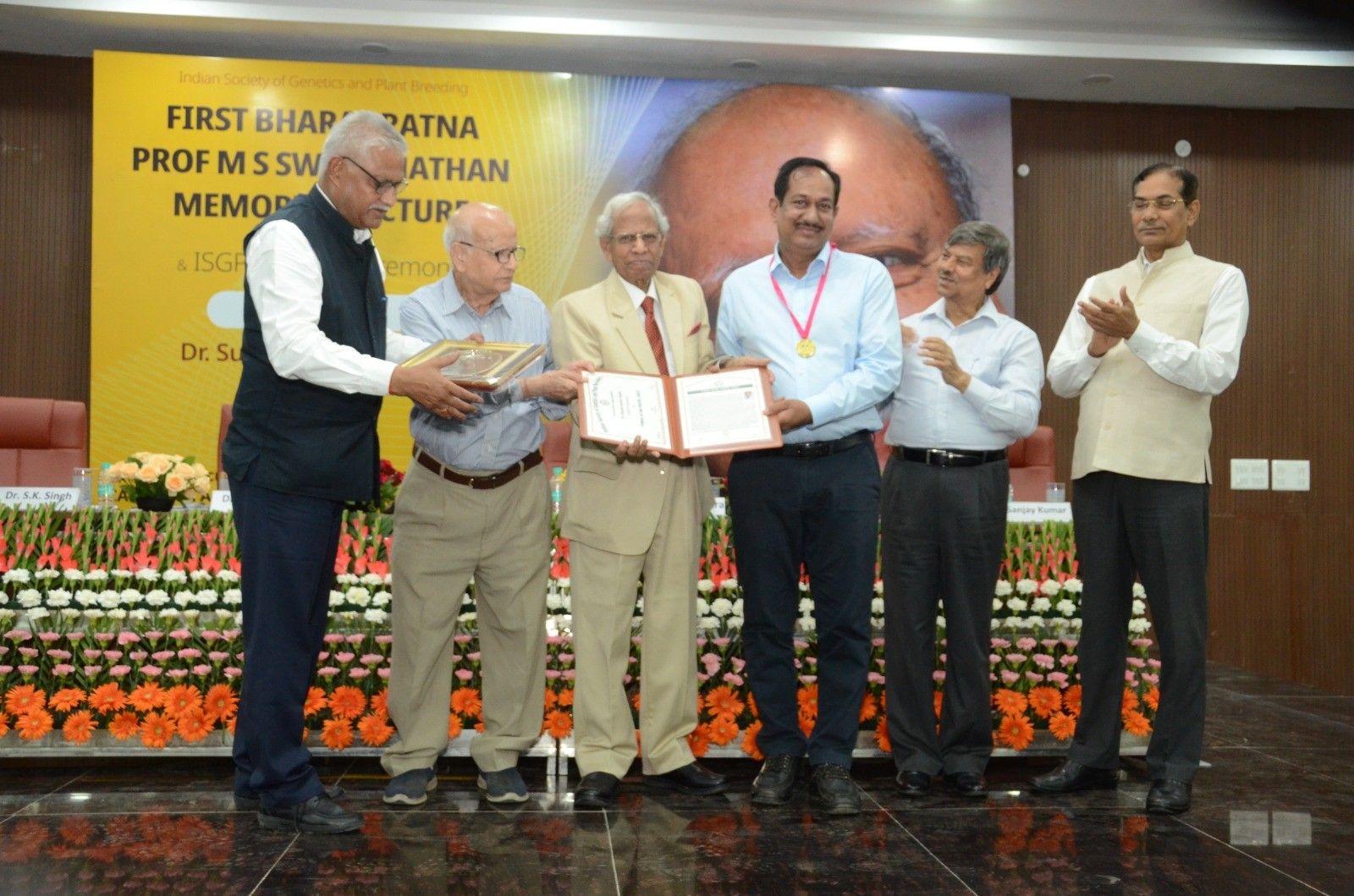 (L-R) Dr Sanjay Kumar, President ISGPB, Dr SK Vasal, Prof. RB Singh, Ex-Director of IARI and ex-Chairman ASRB, Dr SK Gupta, Dr HS Gupta, Ex-Director of IARI, Dr T Mohapatra, ​ Chairperson-Protection of Plant Varieties and Farmers' Rights Authority (PVPFRA), and Ex-DG ICAR at the award ceremony