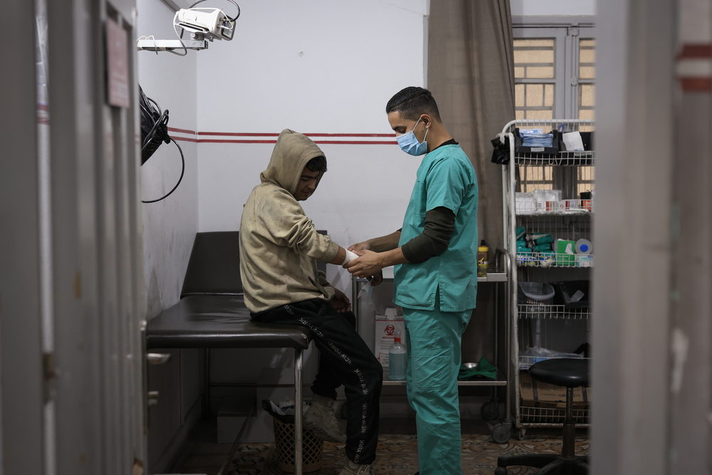 MSF nurse Ahmed is taking care of a patient who was injured in the school where he is currently displaced, at the clinic in Gaza City. Photographer: Motassem Abu Aser | Location: Palestinian Territories | Date: 29/12/2024 MSF nurse Ahmed is taking care of a patient who was injured in the school where he is currently displaced, at the clinic in Gaza City. Photographer: Motassem Abu Aser | Location: Palestinian Territories | Date: 29/12/2024