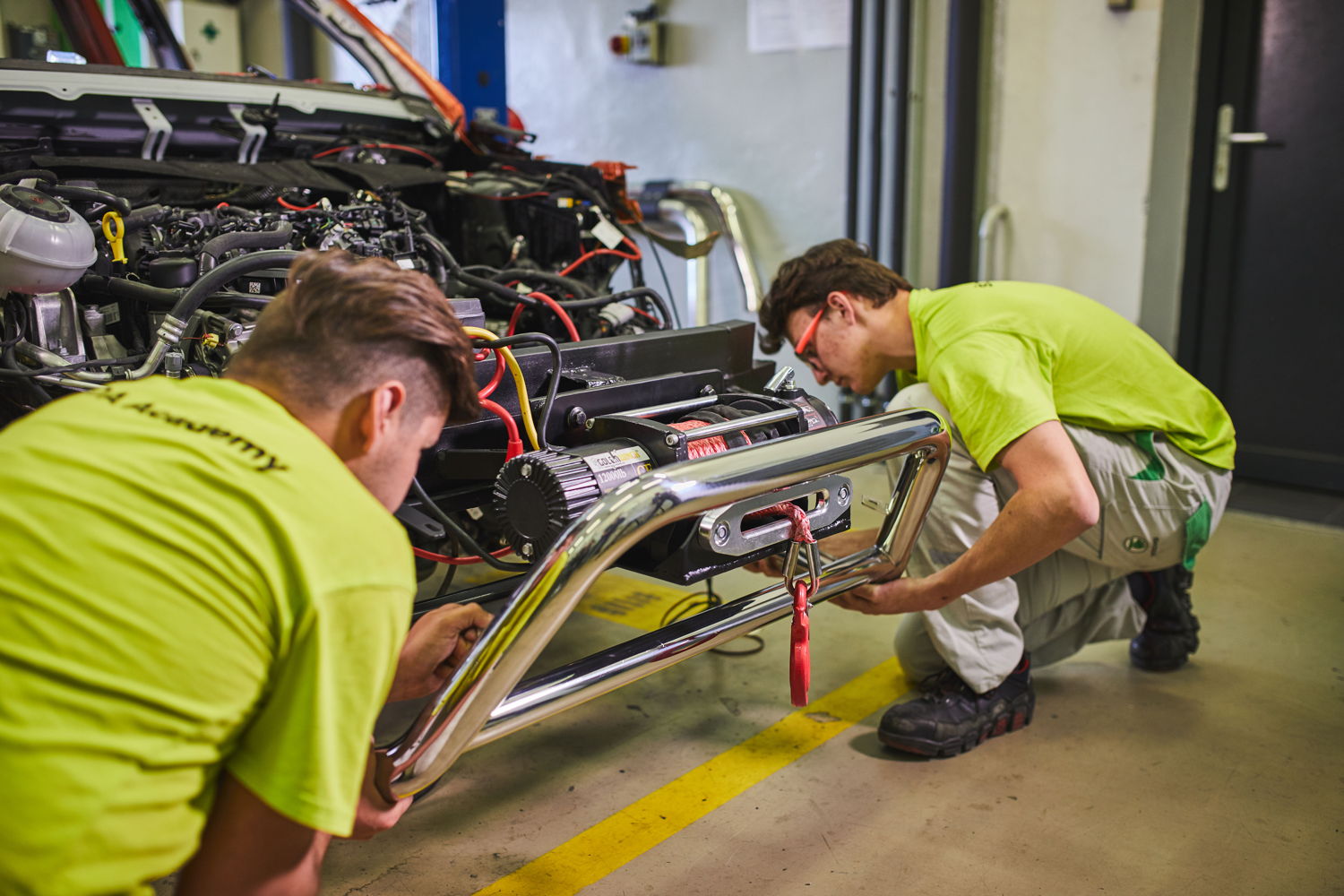 Two apprentices are fitting a bullbar framing a powerful winch
to the front of the ŠKODA MOUNTIAQ.