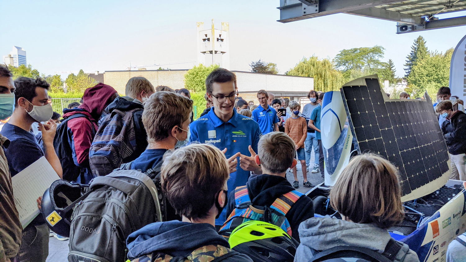 Scholieren verzamelen zich rond de zonnewagen van het Agoria Solar Team