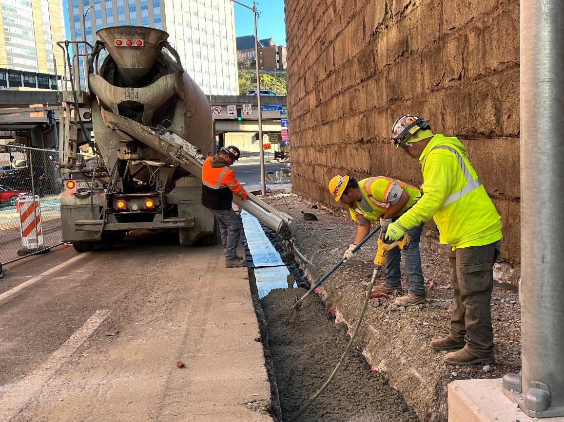 Crews pouring a concrete footer to support the new curb on Sixth Avenue near Diamond Street