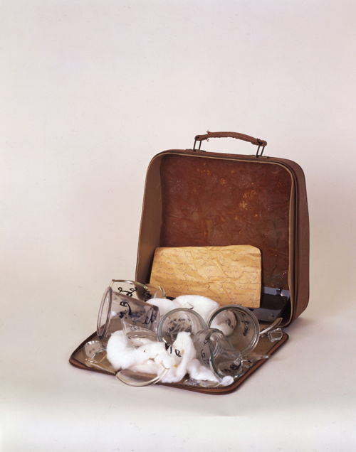 Machine à poèmes, 1965-68. Koffer van een schrijfmachine met bokalen en glasscherven, watten en een handgeschreven brief. 32 × 32 × 18 cm. Collection les Abattoirs, Musée – Frac Occitanie, Toulouse