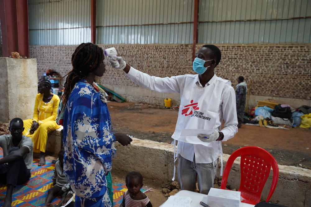 An MSF nurse aide Barnaba checks temperature of a patient in a mobile clinic at the Riverside transit site in Renk, Upper Nile State, South Sudan. Photographer: Nasir Ghafoor | Location: South Sudan |Date: 07/06/2023